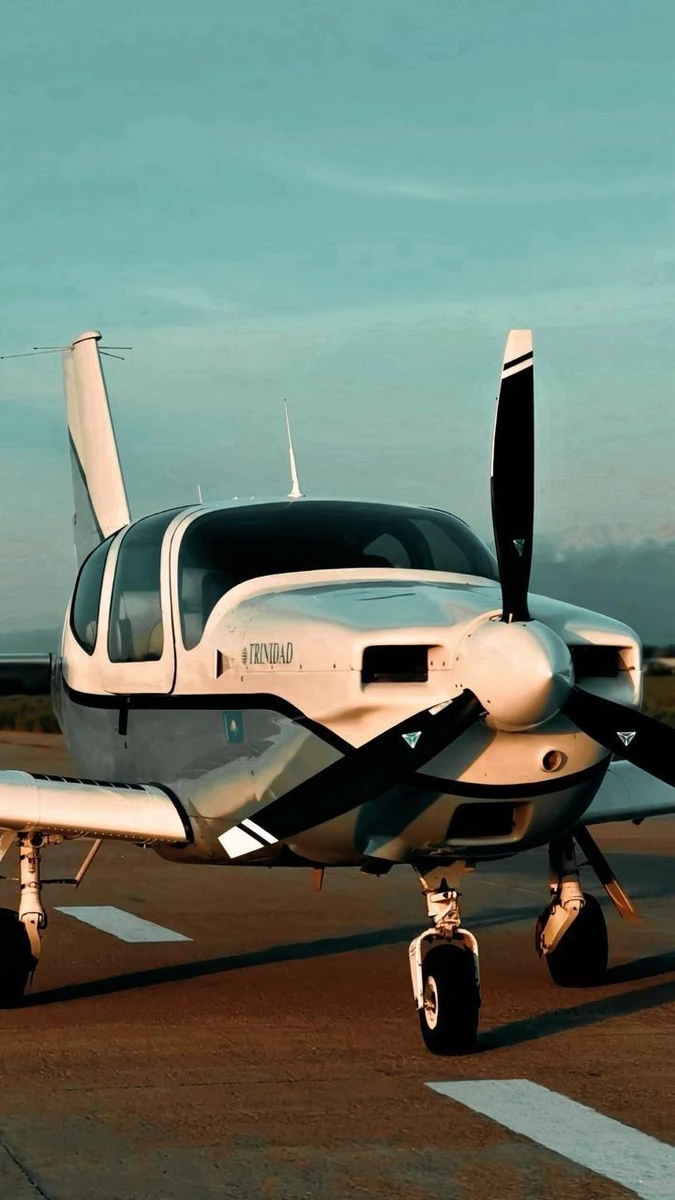 Socata Trinidad aircraft with propeller standing on the runway apron